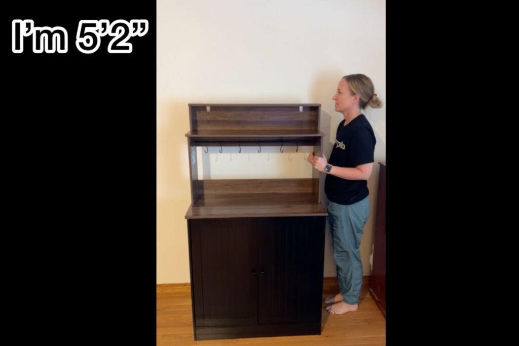 Jen standing next to the coffee bar cabinet to show height