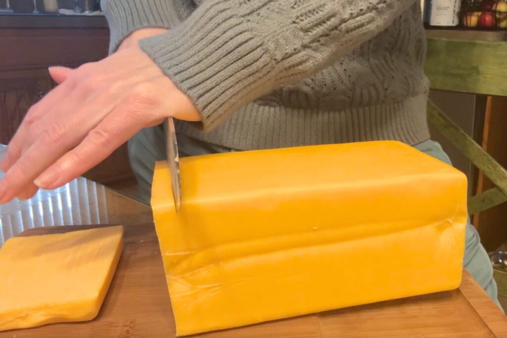 Cutting a block of cheese with a chef knife