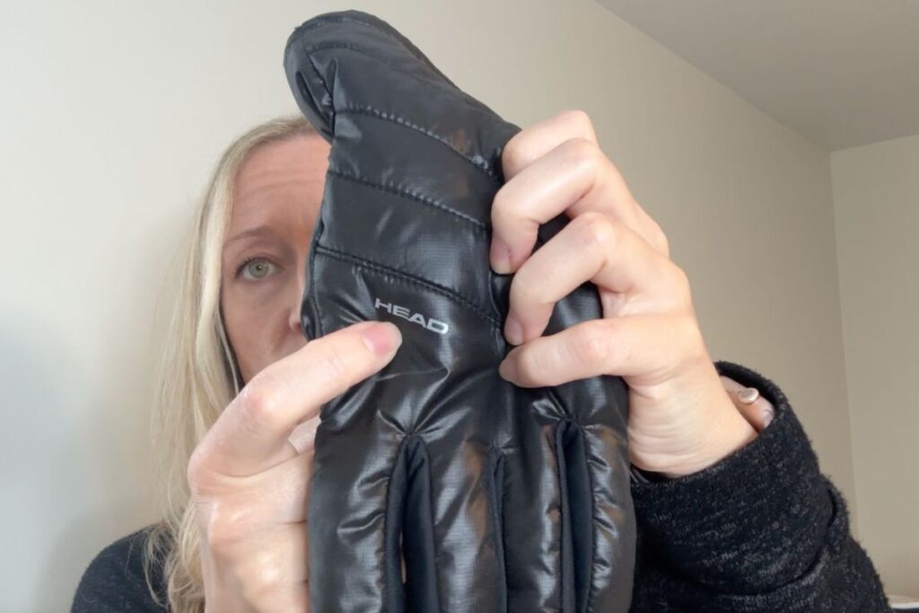 Holding a HEAD winter glove pointing to the brand name