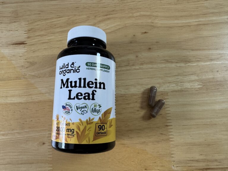 Wild and Organic Mullein Leaf 2000mg bottle on a wood surface with two capsules beside it