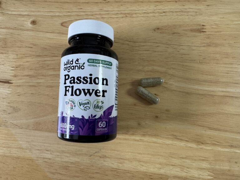 Wild and Organic Passion Flower 600mg bottle on a wood surface with two capsules beside it