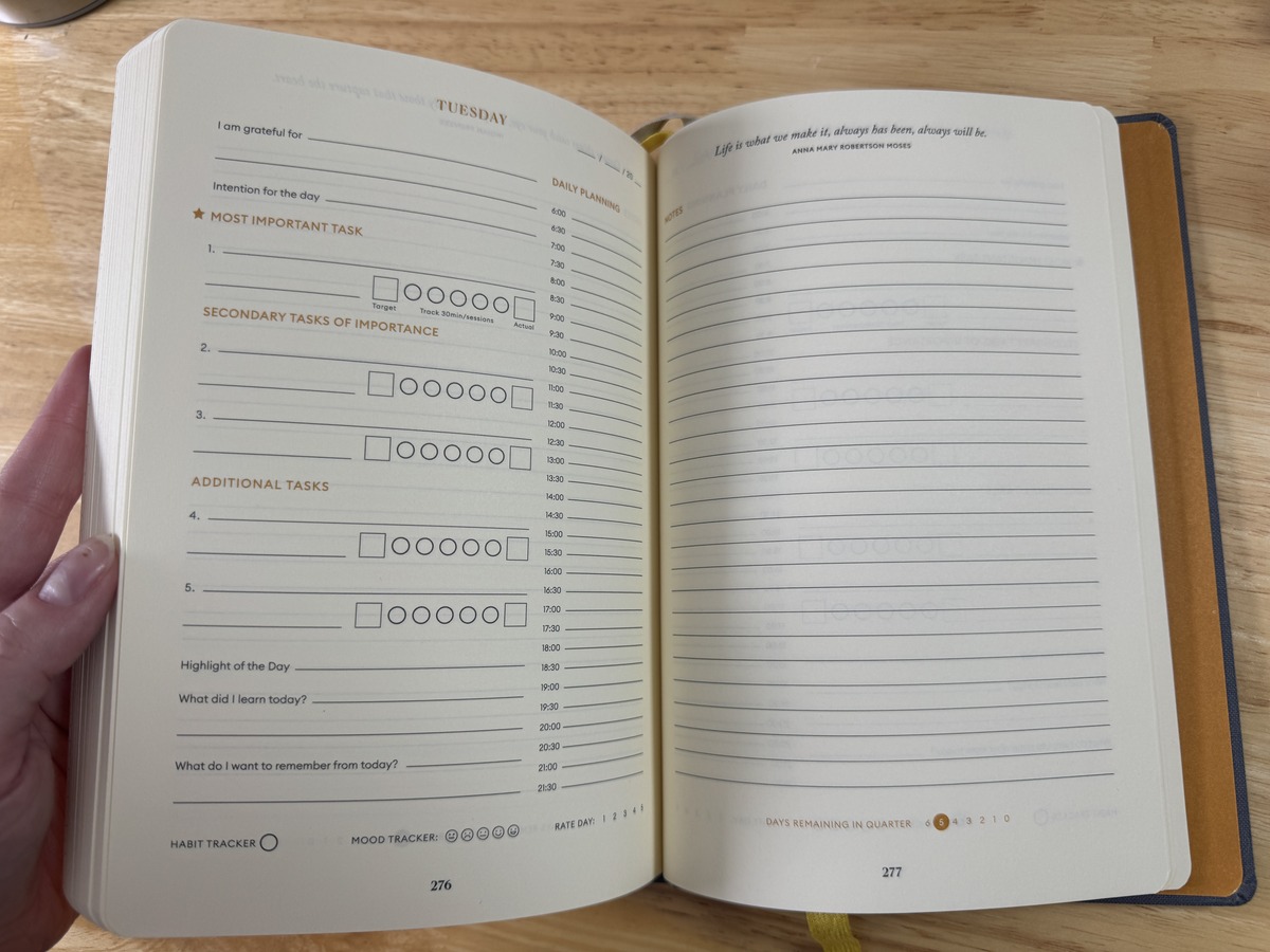 Open Productivity Planner showing a daily task spread facing a blank journal page