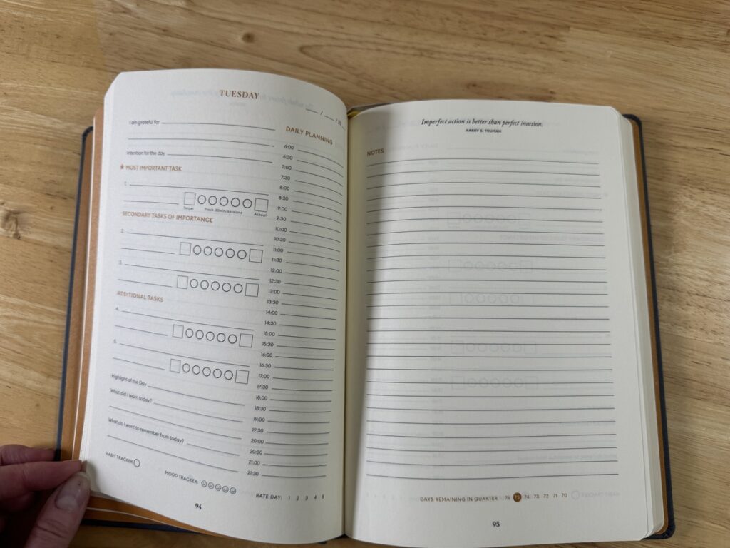 Open Productivity Planner showing the Tuesday daily plan facing a lined notes page
