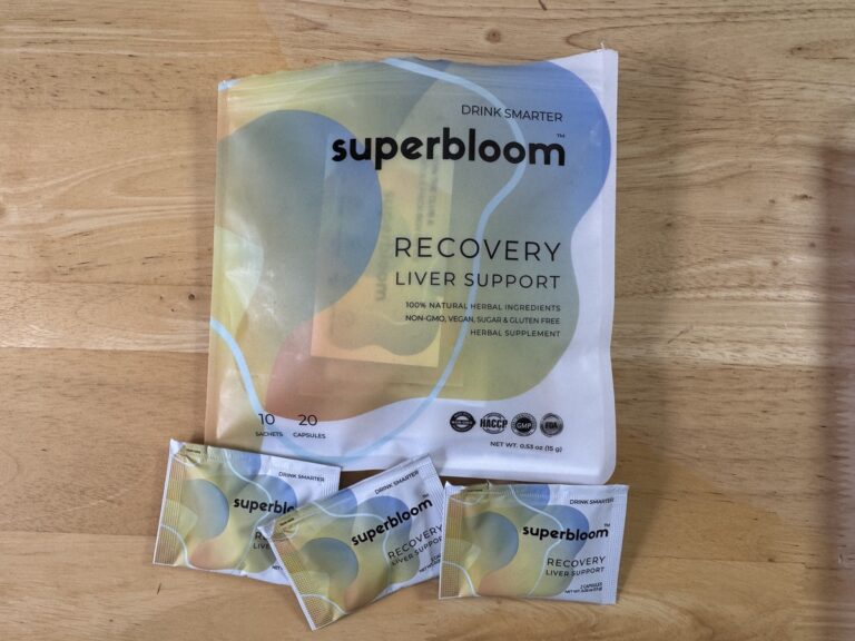Superbloom Recovery liver support pouch on a wood surface with three single-serve sachets in front