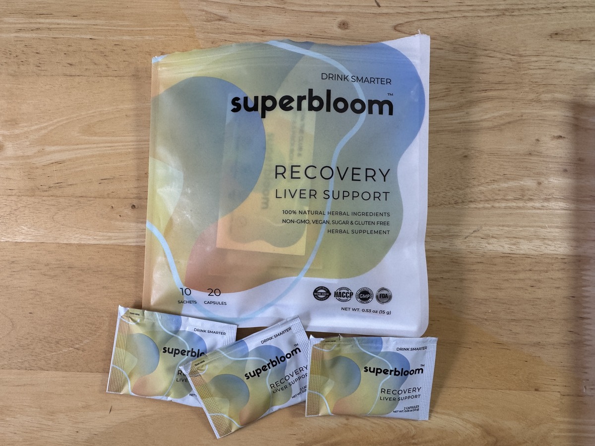 Superbloom Recovery liver support pouch on a wood surface with three single-serve sachets in front
