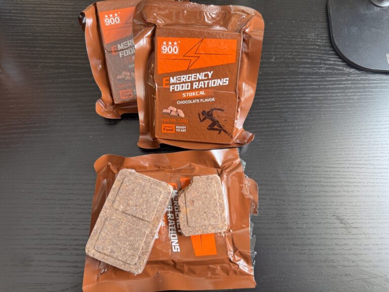 Brown pouches of 900 Emergency Food Rations Chocolate Flavor 570 kcal, one opened showing compressed ration bars.
