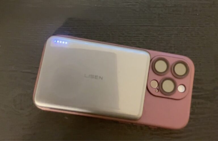 Jen holds up a black Lisen Phone Accessories power bank box with purple branding in a bedroom.