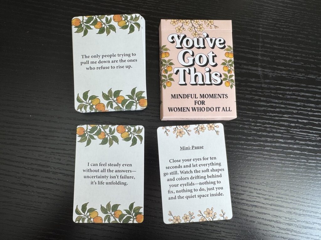 You've Got This Mindful Moments card deck box with three affirmation cards fanned out on a dark wood surface.