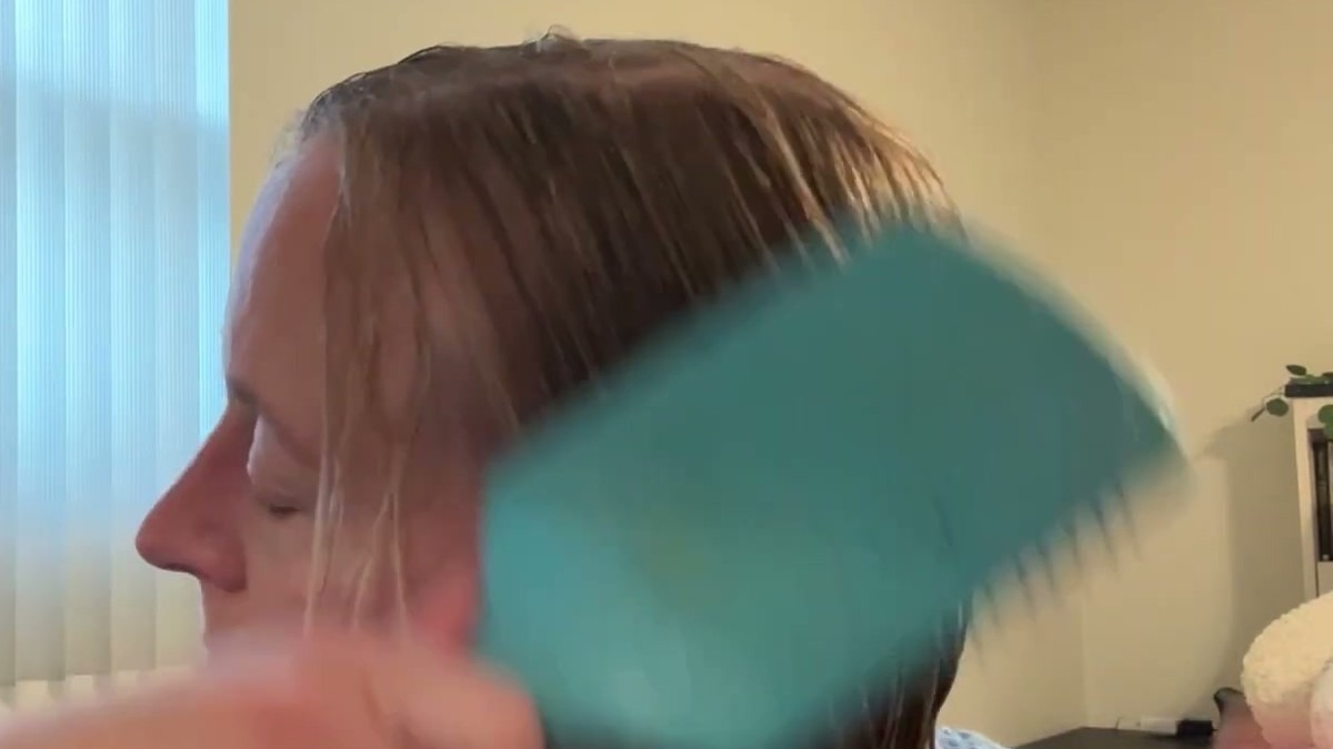 A brush pulling through freshly washed wet hair after using the AHSUO hard water shampoo and conditioner
