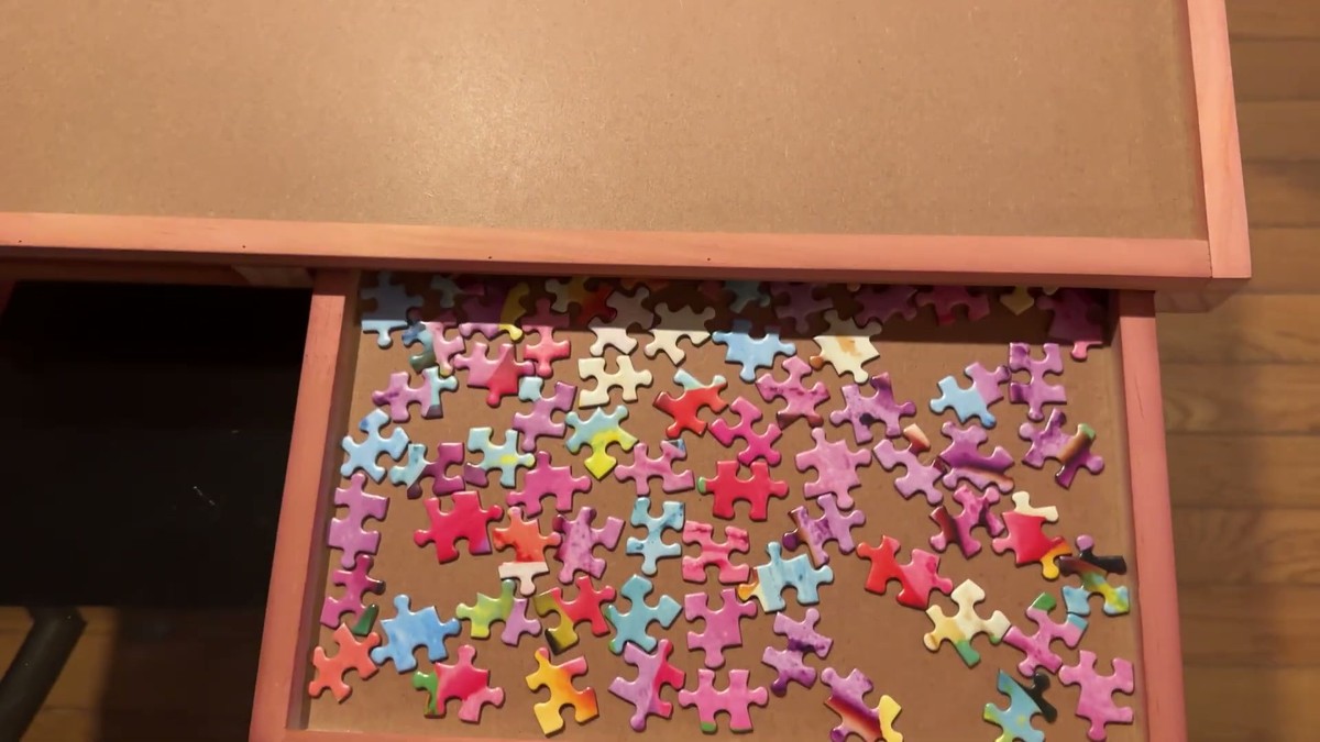 Sliding drawer of the Bits and Pieces puzzle lounger pulled out and full of sorted puzzle pieces