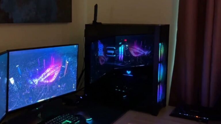 Black Corsair 7000D AIRFLOW full-tower case with RGB fans glowing through the front mesh, sitting on a desk beside two monitors and a lit keyboard