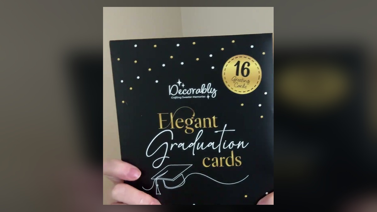 Decorably 16 pack elegant graduation cards, the black and gold box held up to the camera