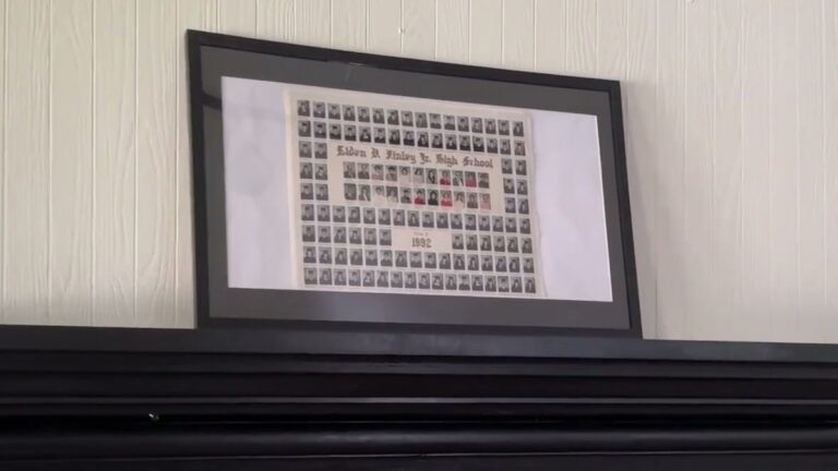 DoubleFill 11x22 newspaper frame with a black mat holding a 1992 school composite photo, propped on a black mantel