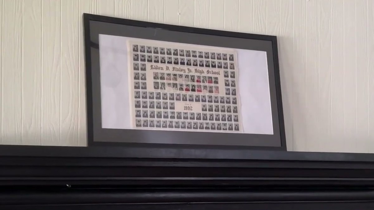 DoubleFill 11x22 newspaper frame with a black mat holding a 1992 school composite photo, propped on a black mantel