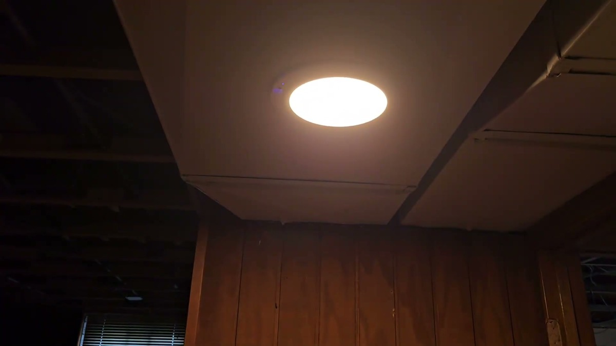 Fsaox rechargeable ceiling light stuck to exposed ductwork and lit warm white in an unfinished closet