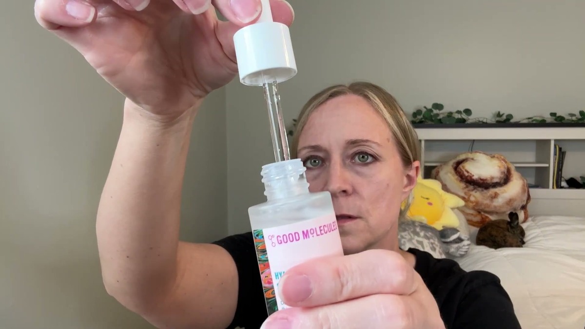 Jen lifting the glass dropper out of the Good Molecules Hyaluronic Acid Serum bottle
