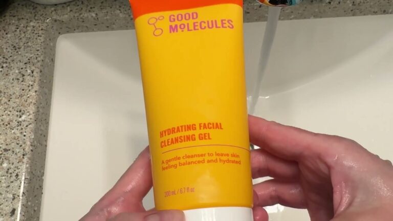 Good Molecules Hydrating Facial Cleansing Gel in its orange and yellow 6.7 oz tube, held over a bathroom sink