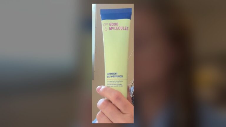 Good Molecules Lightweight Daily Moisturizer tube, pale green with a blue cap end and pink logo, held upright with the front label facing the camera