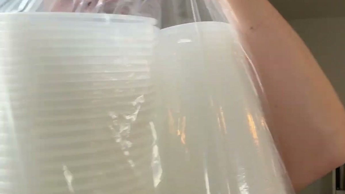 Two tall stacks of clear GUSTO deli containers and lids lifted out of the packaging bag