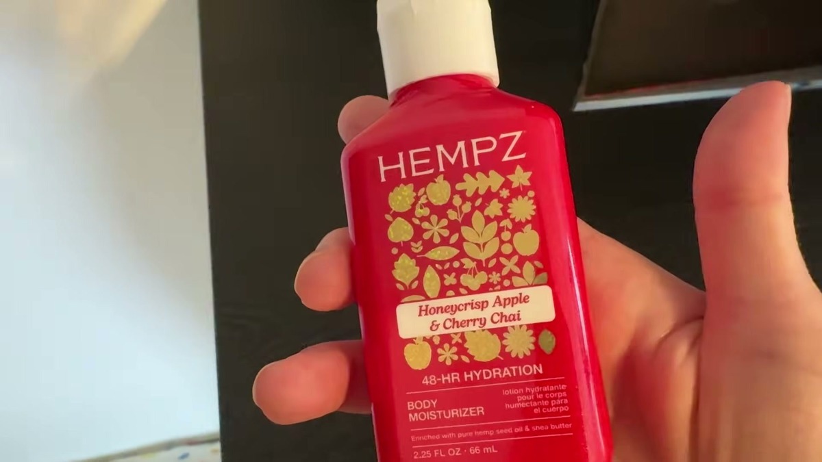Hempz Mini Honeycrisp Apple and Cherry Chai body moisturizer, a small red 2.25 oz bottle with gold apple and leaf graphics and a white flip cap