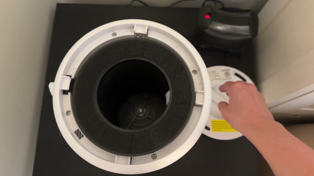 MOOKA air purifier turned over with the bottom cover twisted off, showing the round black filter seated inside the base