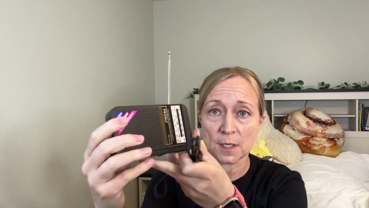 Jen holding the Pronly radio in one hand with the antenna extended, showing how it fits inside her palm