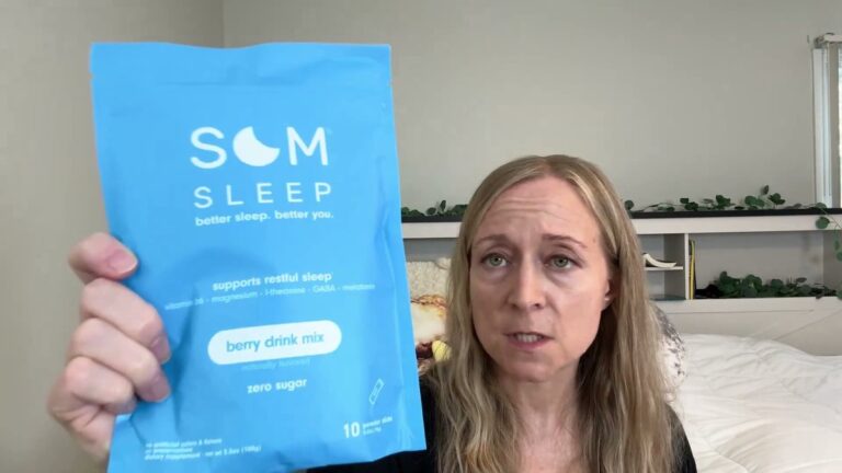 Blue Som Sleep berry drink mix pouch with 10 stick packs held up in front of a bed