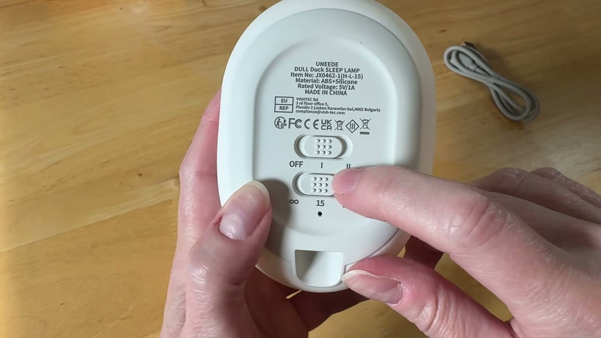 Underside of the UNEEDE Benson duck night light showing the OFF, I, and II switch and the 15 and 30 minute timer buttons on the white silicone base