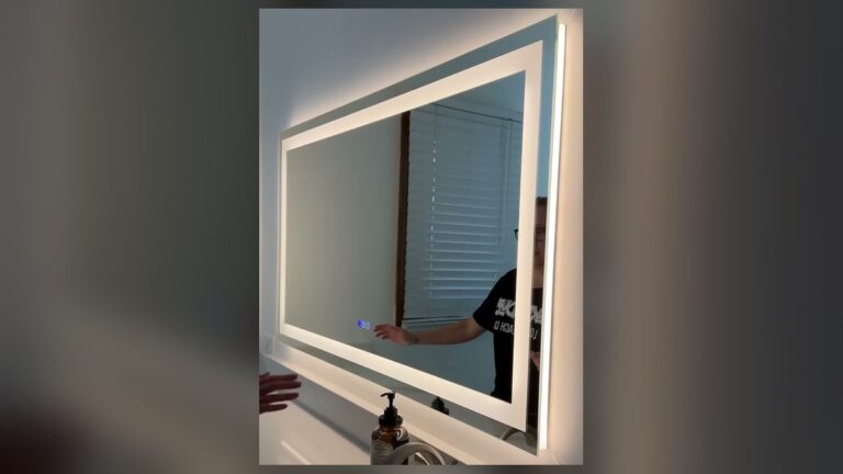 Amorho 36 by 32 inch LED bathroom mirror lit up over a white quartz vanity, with a bright front light frame and a warm backlit glow on the wall.