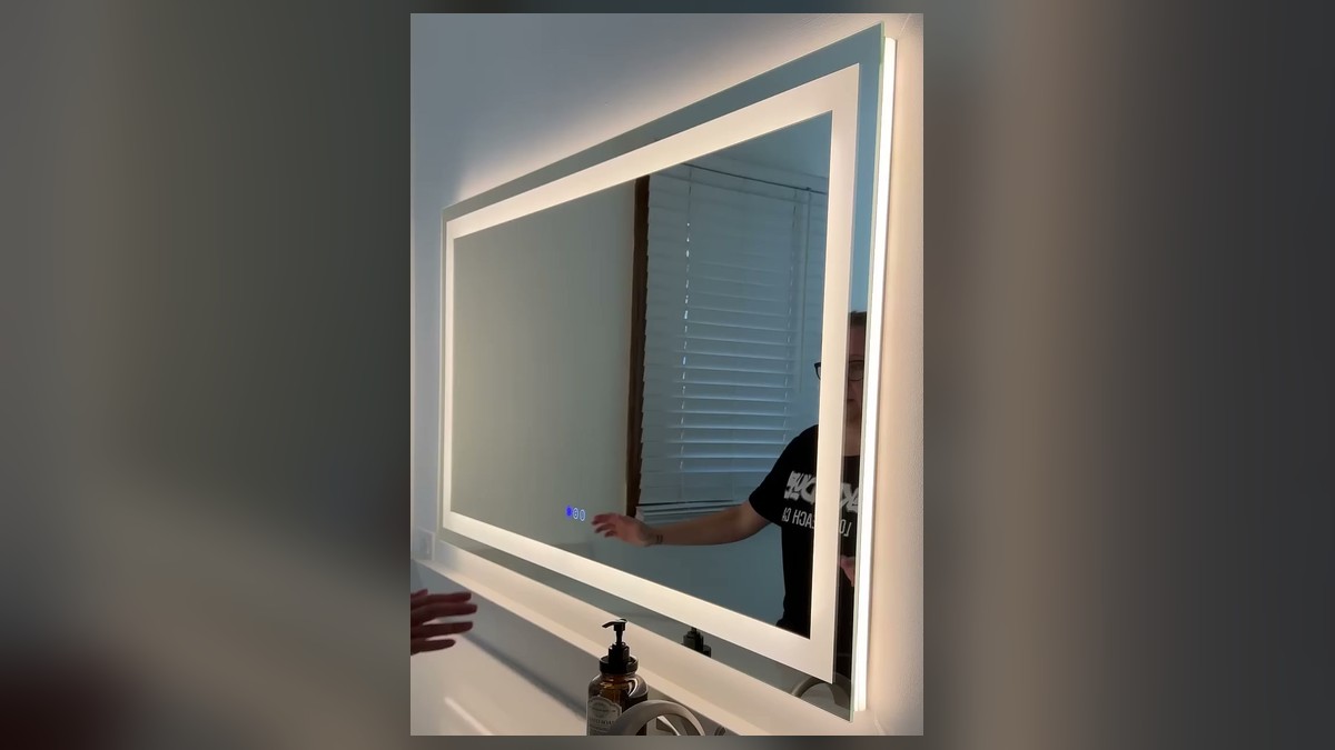Amorho 36 by 32 inch LED bathroom mirror lit up over a white quartz vanity, with a bright front light frame and a warm backlit glow on the wall.