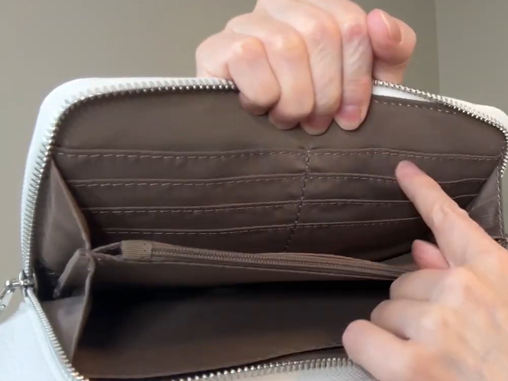 The befen fanny pack's front pocket unzipped to show a taupe wallet lining with rows of card slots and a zippered cash pocket.
