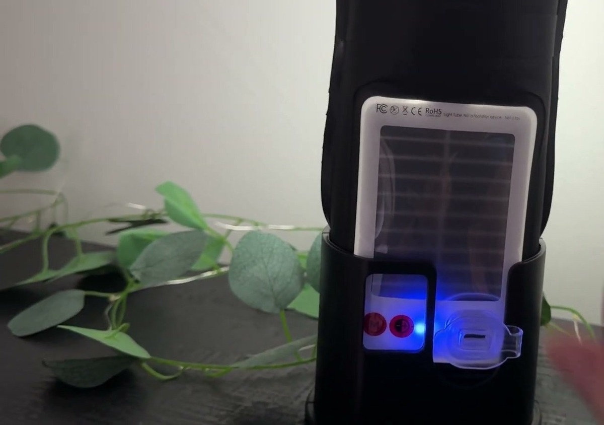 Close-up of the BILTRTE lantern's built-in solar panel with its red mode buttons and glowing blue USB-C charging port in the base slot