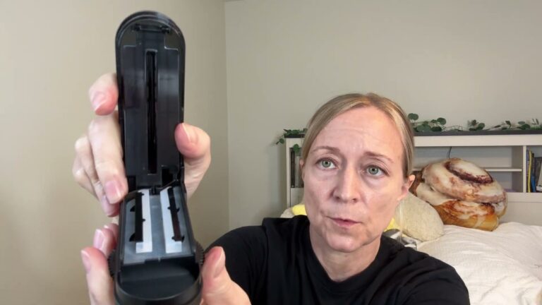 Jen holding the black DEPAD pill cutter open to show the two silicone bars inside