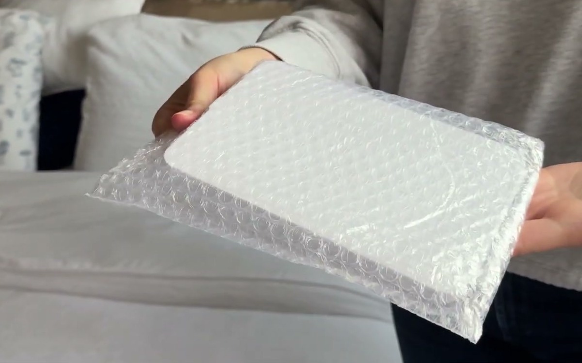 Folded FUNTOUCH travel mirror tucked inside the small bubble pouch it comes in