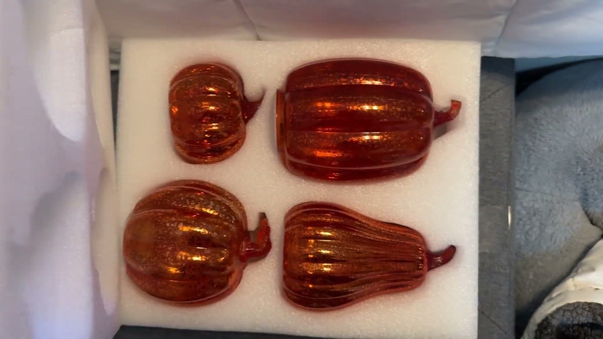 Four orange mercury-style glass pumpkins in four sizes nestled in white foam packaging