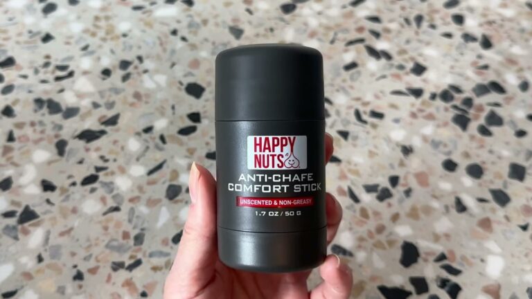 Hand holding a dark gray HAPPY NUTS Anti-Chafe Comfort Stick labeled unscented and non-greasy, 1.7 oz