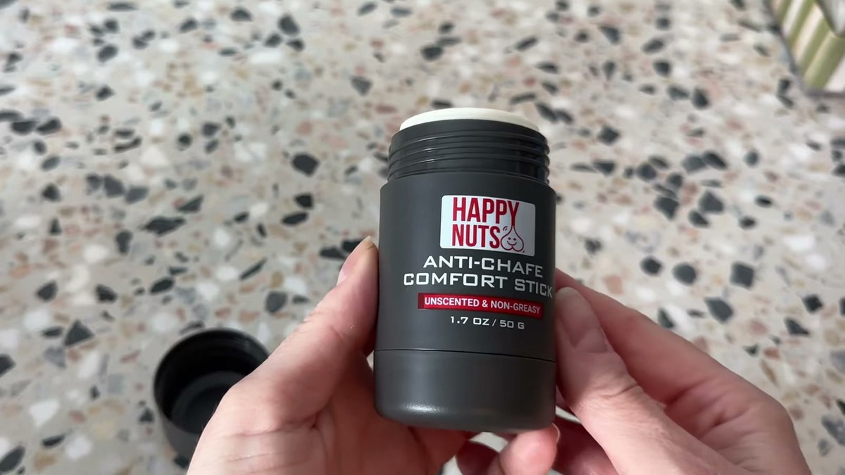 HAPPY NUTS Comfort Stick with the cap off showing the white stick inside, cap resting on the counter