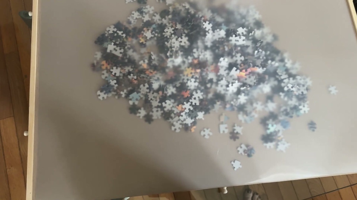 Frosted plastic cover laid over an unfinished puzzle on the PlayVibe board to keep the pieces in place