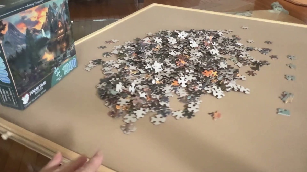 PlayVibe wooden rotating puzzle board with a 1000-piece puzzle spread across it and the puzzle box sitting on the edge