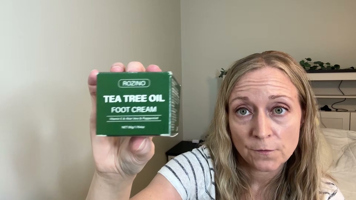Jen holding up the small green Rozino Tea Tree Oil Foot Cream box