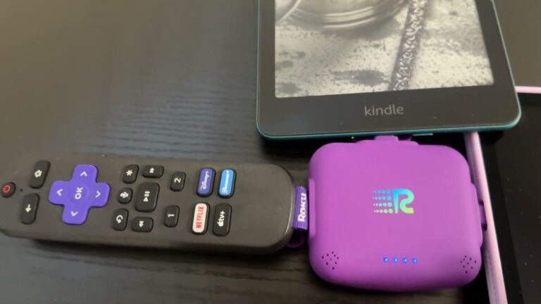 Purple Rush Charge Universe mini power bank charging a Roku remote, a Kindle and an iPad at the same time, its four blue battery lights on