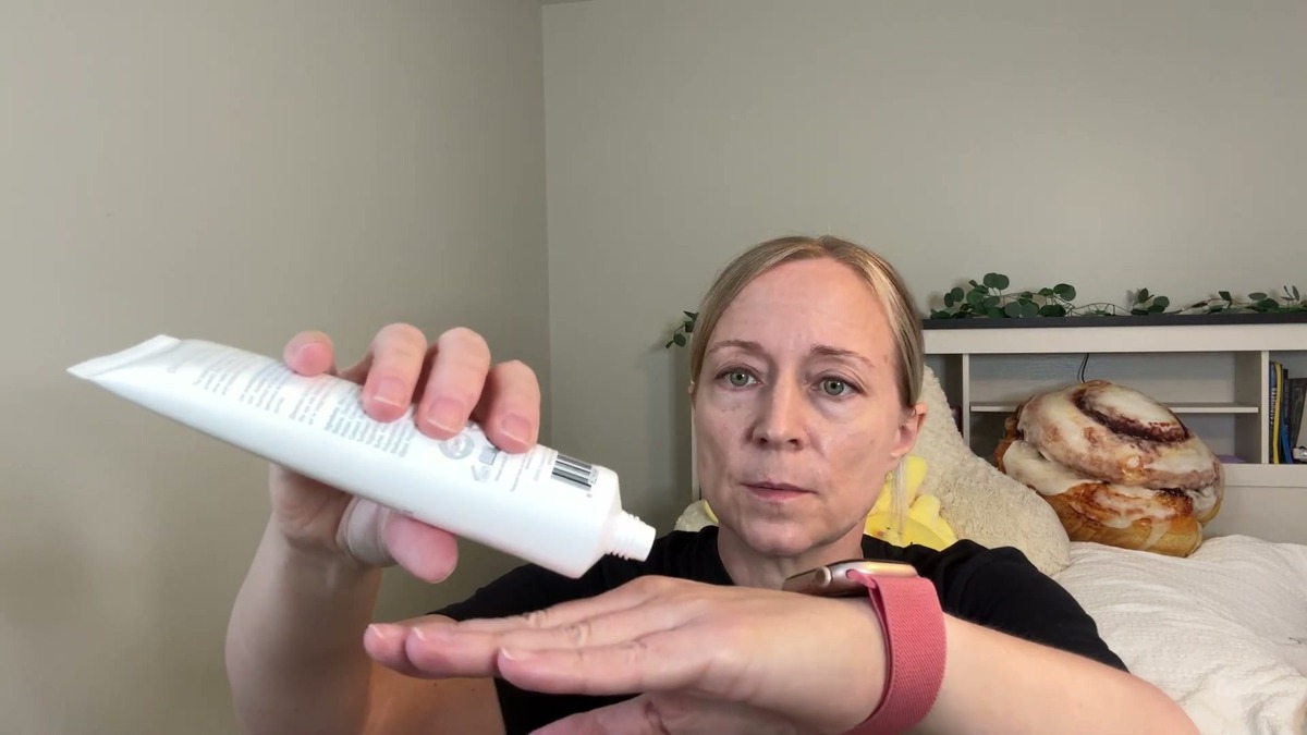 Jen squeezing Vivo Per Lei day cream from the white tube onto the back of her hand