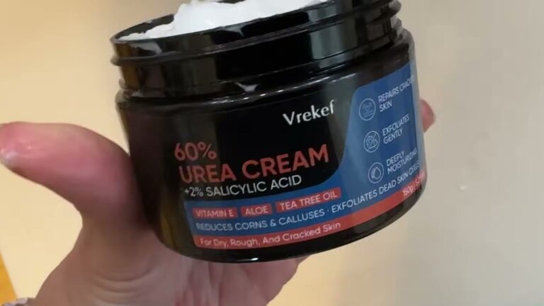 Hand holding a black tub of VREKEF 60% Urea Cream with 2% salicylic acid, label listing vitamin E, aloe and tea tree oil
